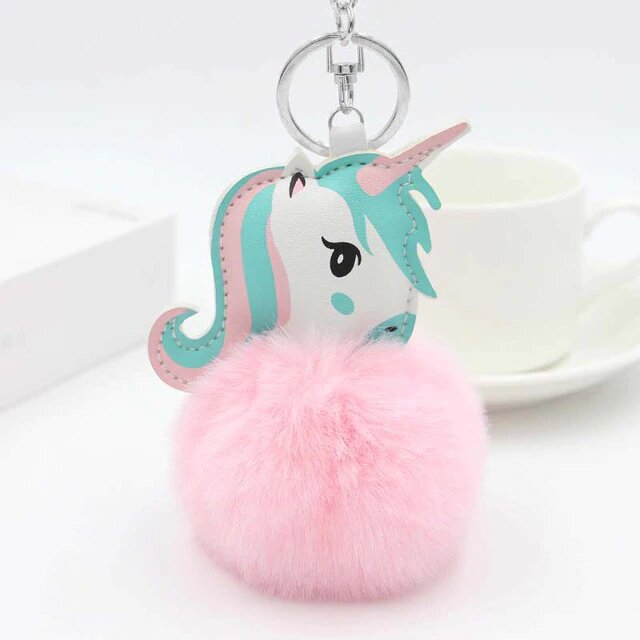 un porte cle licorne avec un pompon rose